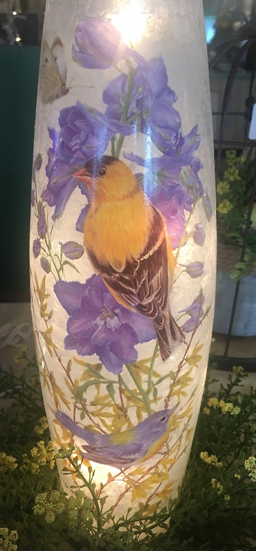 Yellow finch and Delphinium light up